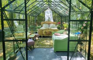 a green room with a bed in a greenhouse at Logements Insolites, Les Rêves d'Ambre 