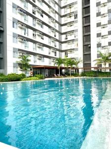 a large swimming pool in front of a building at CDO Cozy 2-Bedrooms 2 Toilets View Pool and Garden beside Ayala Mall in Cagayan de Oro
