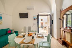 a living room with a table and a green couch at Dimora EgiLò in Nardò +32 photos