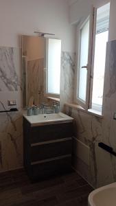 a bathroom with a sink and a mirror at Torvajanica Antonella in Torvaianica +15 photos