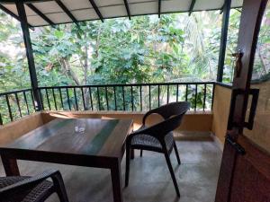 a balcony with a wooden table and two chairs at Orient Lodge - Galewela in Beligamuwa