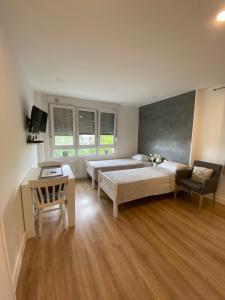Un dormitorio con dos camas y una mesa y un escritorio. en Lea Studios, en Zagreb