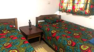 a bedroom with two beds and a table with a bedspread at Tiko Community Centre in Saint Francis +34 photos