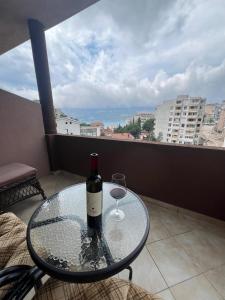 a bottle of wine and a glass on a table on a balcony at Apartments Lav Costas in Herceg-Novi