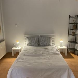 a bedroom with a large white bed with two lamps at Rosemary studio in Nea Kallikrateia