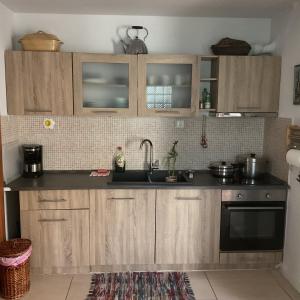 a kitchen with wooden cabinets and a sink at Rosemary studio in Nea Kalikratia