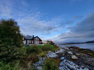a house on the shore of a body of water at Hytte ved sjøen in Røyra