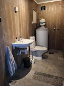 a bathroom with a toilet and a sink at Hytte ved sjøen in Røyra +14 photos
