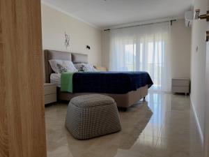 a bedroom with a bed and a ottoman in the foreground at Sunset Serenade Apartment in Dapkovi°i +10 photos