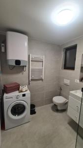 a bathroom with a washing machine and a toilet at Calypso Sea View Apartament Saranda in Sarandë