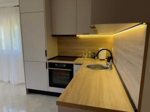 a kitchen with a sink and a stove at Sunset Serenade Apartment  +11 photos