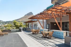 un patio con mesas y sillas con una montaña en el fondo en FortyOnL Luxury Apartments, en Ciudad del Cabo