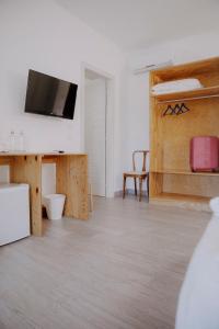 a white room with a tv and a desk with a chair at Le Vie di Feronia in Terracina