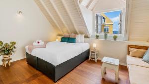 ウィレムスタッドにあるPietermaai Boutique Hotelの大きなベッドとソファのある寝室