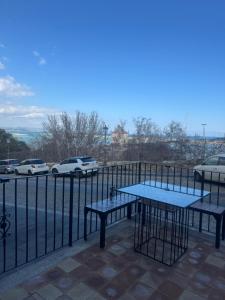 two picnic tables on a balcony with a view of cars at Arco di Pietra B&B in Crotone