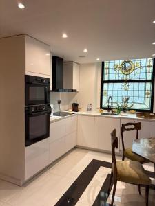 a kitchen with white cabinets and a table and a window at Luxury Duplex 2BR Panoramic Sea View Monaco in Beausoleil