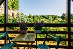 una mesa de madera con dos macetas en un porche en Domek pod bukami, en Szymbark