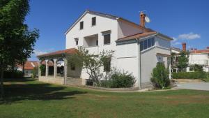 een wit huis met een tuinhuisje in een tuin bij Apartment Suzy in Vantačići