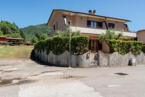 a house with a stone retaining wall in front of it at La Casa di Roby in Bagni di Lucca