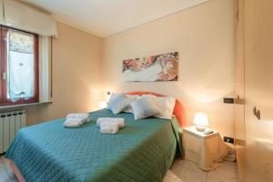 a bedroom with a green bed with towels on it at La Casa di Roby in Bagni di Lucca