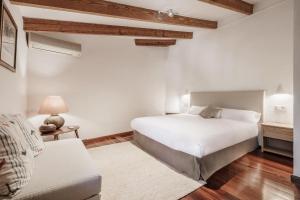 a bedroom with a white bed and a couch at The Old Cottage - Cas Julians Sencelles Ruberts in Sencelles