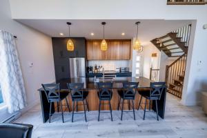 a kitchen with a large dining room table and chairs at Spa - Chalet la Barque du Bonheur in Sainte-Germaine-du-Lac-Etchemin +31 photos