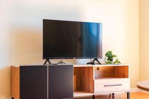 a flat screen tv sitting on top of a wooden entertainment center at Bright & Comfy 2BR Apartment by the Adriatic in Durrës
