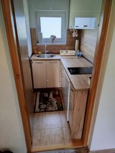 a small kitchen with a sink and a window at Apartmani LIDER Visoko in Visoko