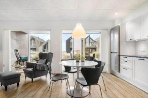 a kitchen and dining room with a table and chairs at 9930-Hvide-Sande-Langsand-106-stuen in Hvide Sande