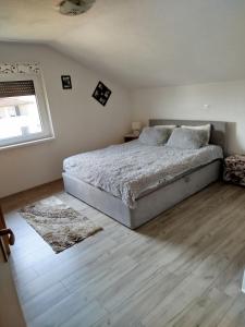 a bedroom with a large bed and a window at Apartmani LIDER Visoko in Visoko +6 photos