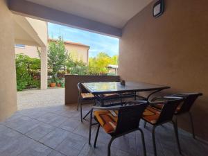 a dining room with a table and four chairs at Apartmani EMA in Nin