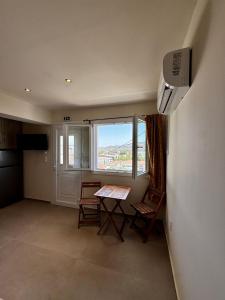 a room with a table and chairs and a window at Kotronia Suites in Skiathos Town