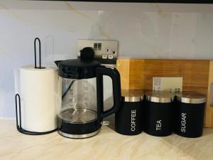 a blender sitting on a counter next to some cups at Stylish 2-Bedroom Modern Flat in Dundee