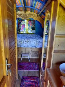 a small room with a bed and a bench in it at Roulotte LA Bohémienne in Grosbreuil