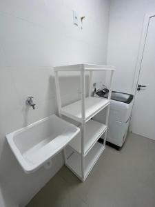 a small white bathroom with a sink and a sink at Loft Studio 101 em São José à 7km de Floripa in São José