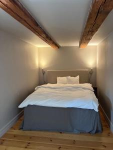 a bed with white sheets and pillows in a room at Snickarboden - Cozy farmstay near forest & lake in Ingelstad