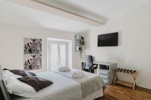 a white bedroom with a bed and a desk at The Boutique Apartment in Parma