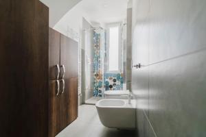 a bathroom with a tub and a sink and a toilet at The Boutique Apartment in Parma +29 photos