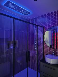 ル・ムイにあるLe Ryokan douche sensorielleのバスルーム(シンク、紫色の照明付きシャワー付)