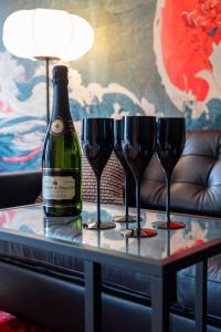 ル・ムイにあるLe Ryokan douche sensorielleのワイングラス付きのテーブルに置かれたボトルワイン