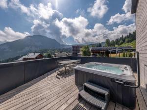 una vasca idromassaggio su una terrazza con vista sulle montagne di Magnifique appart 6 personnes près des pistes avec SPA et Parking à Courchevel 1550 - FR-1-631-207 a Courchevel