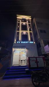 a building with a sign that says we must live at VV Guest Inn in Nellore