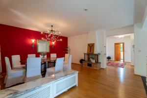 a dining room with a table and a red wall at LAKE VIEW! Chalet Birkmayer by we rent in Zell am See