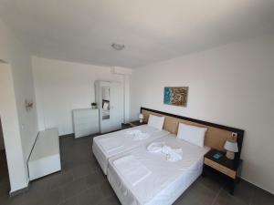 a bedroom with a large bed with white sheets at Apartments Lozenets in Lozenets