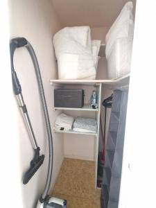 a room with a shelf with towels and a vacuum at Le Nélaton #Confort in Clermont-Ferrand