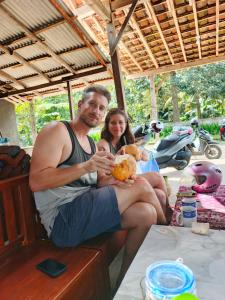 a man and a woman sitting on a table at Tiara Homestay Banyuwangi in Banyuwangi