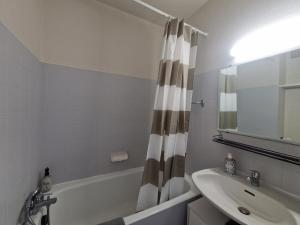 a bathroom with a sink and a shower curtain at Le Nélaton #Confort in Clermont-Ferrand