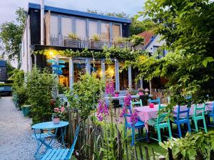 a garden with a table and chairs in front of a building at In de Aap - Appartementen & Guesthouse in Bergen