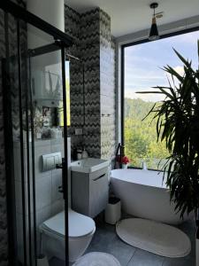 a bathroom with a tub and a toilet and a window at Forest Hub in Slavske