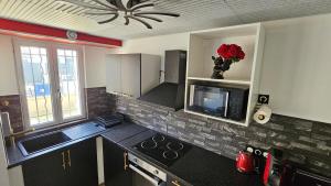 a kitchen with a sink and a stove top oven at La Suite Rouge Proche Paris & Stade De France in Drancy